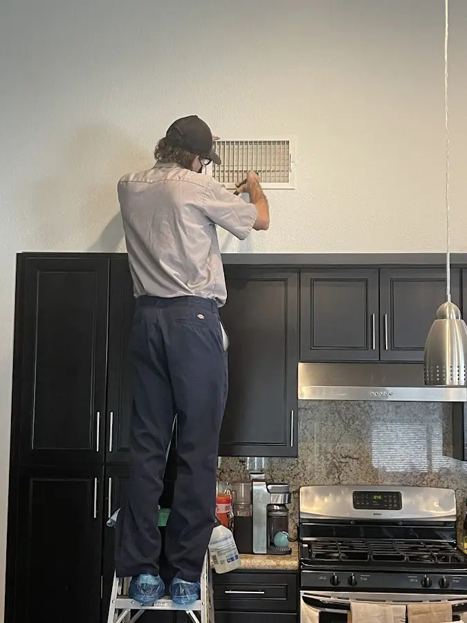 Technician inspecting an air vent during HVAC service in Front Royal